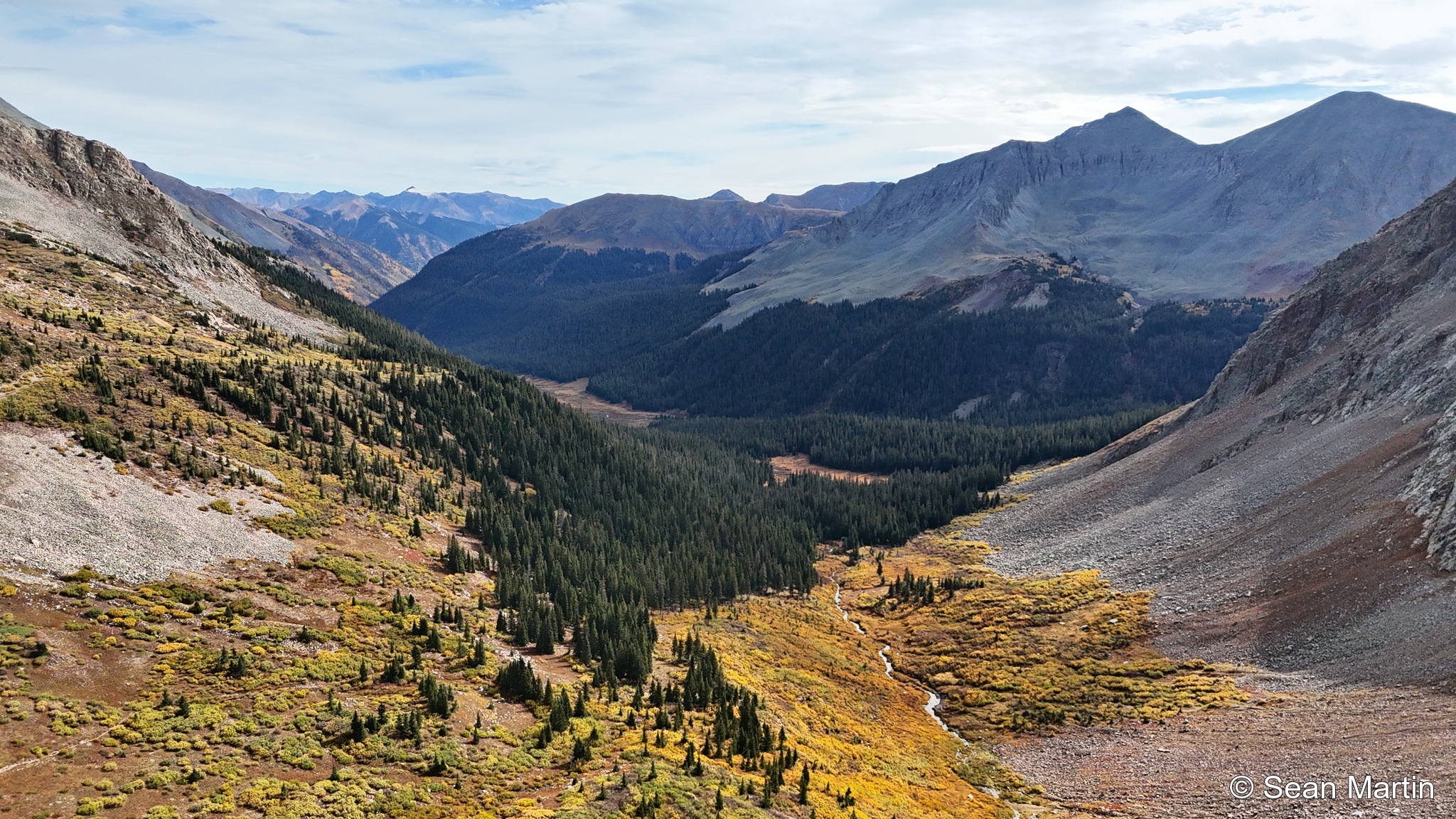 Autumn colors along the valley below the mountains